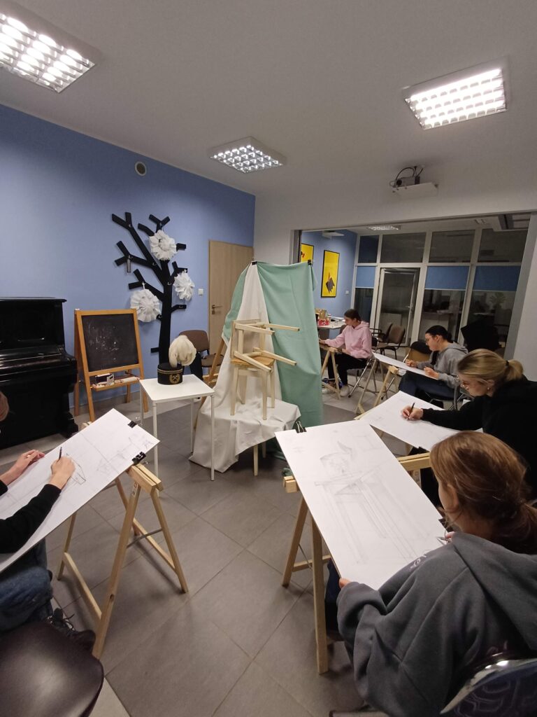Kursant rysuje temat: martwa natura: krzesło w perspektywie, studium krzesła.